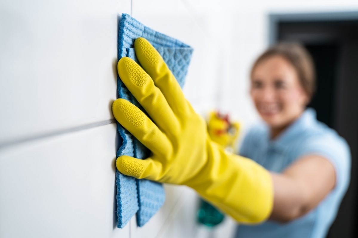 The person cleaning the wall with a cloth